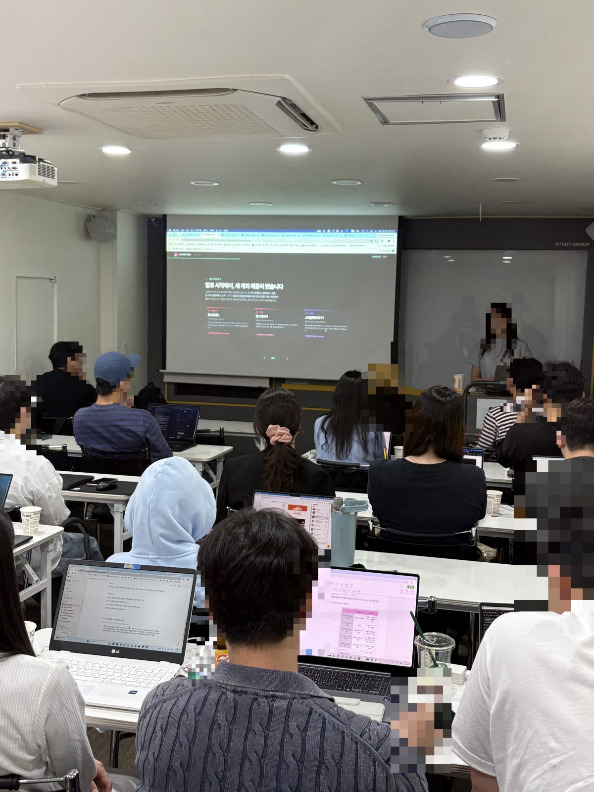 졸업생이 만든 제품 세 개가 카드로 정리된 쇼케이스 화면을 프로젝터로 띄운 장면